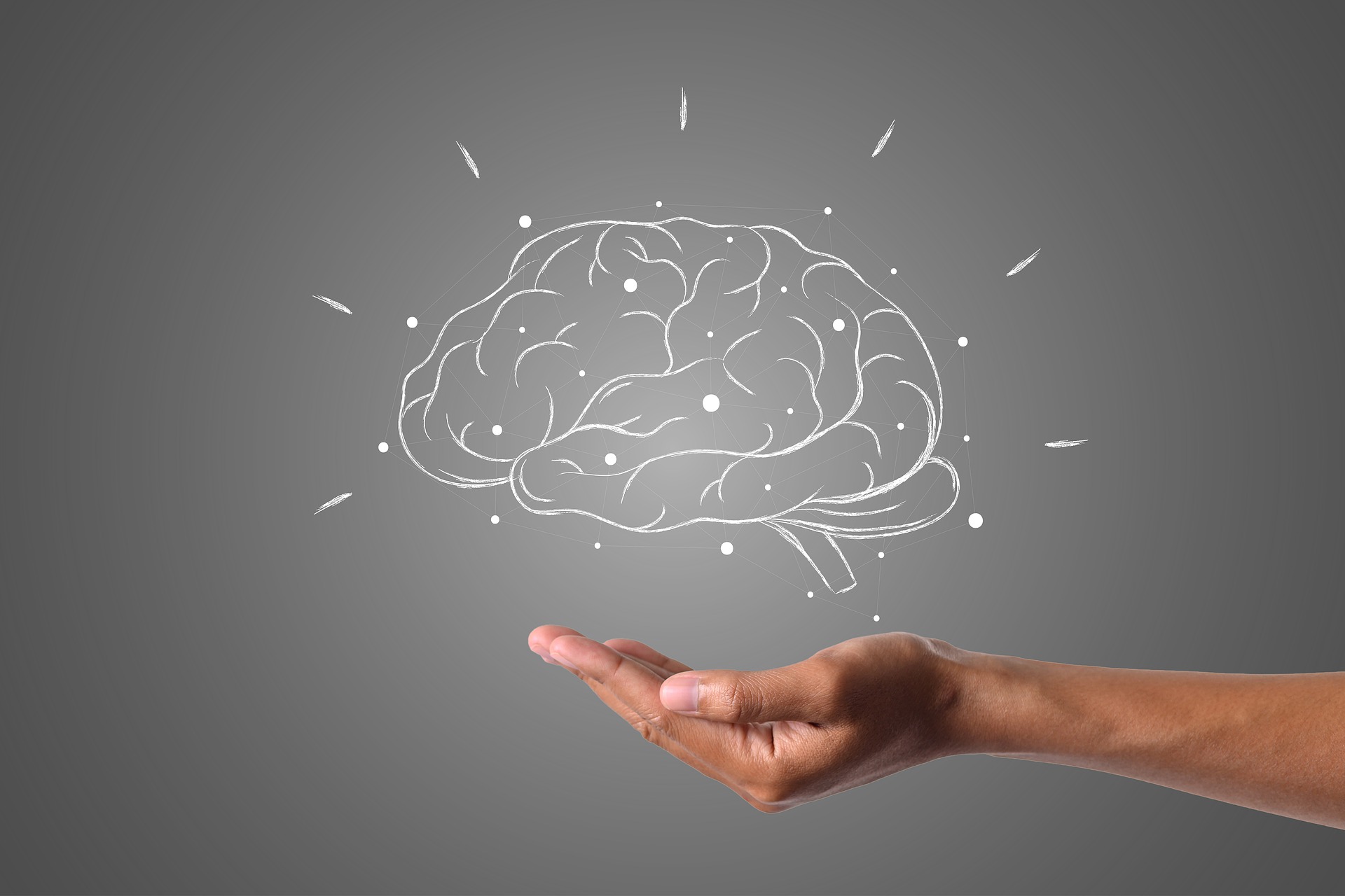 An upturned palm with an illustration of a human brain floating above it.